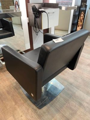 une photo d'un salon de coiffure avec un fauteuil et un miroir