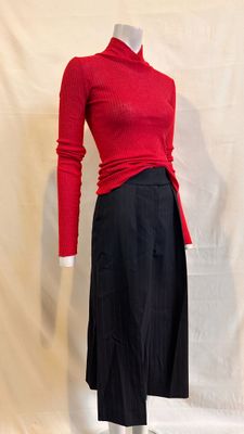 a mannequin wearing a red sweater and black skirt
