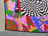 a multicolored quilt on the floor with a black and white background