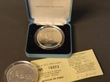 a close up of a coin in a box with a ticket