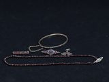 an image of a necklace and a bracelet on a black surface