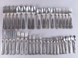 a lot of spoons and forks laid out on the table