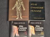 three books on a table with a black background and a brown cover