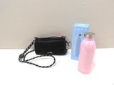 a pink bottle and a black bag on a white table