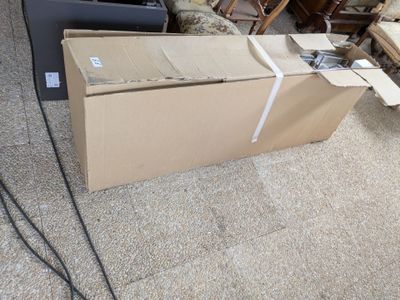une boîte posée par terre à côté d'une chaise