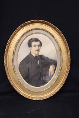 an old picture of a man in a suit and tie sitting in front of a black background