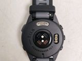 a close up of a black watch on a white surface