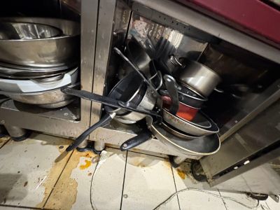 pots and pans that are on the floor in the kitchen
