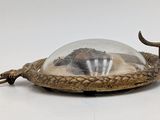 a small metal object with a glass dome on top of it