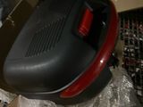 un sèche-cheveux noir et rouge posé sur une boîte en carton