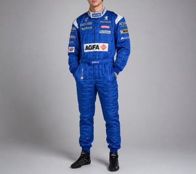 un homme vêtu d'une combinaison de course bleue, debout devant un fond gris