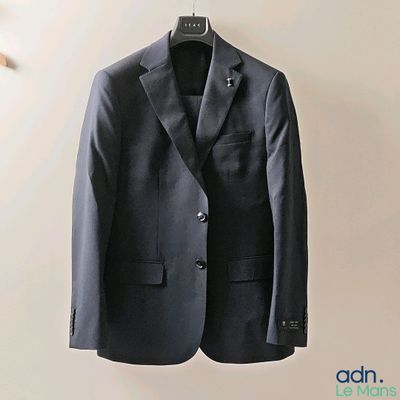 a suit hanging on a hanger on a wall