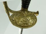 a close up of a gold sword with a black handle