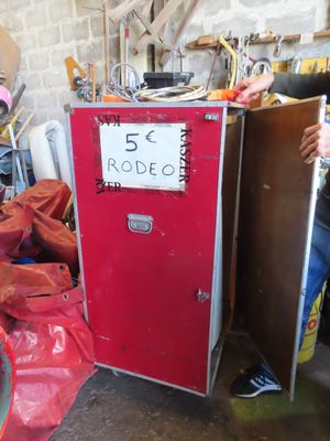 a man standing next to a red refrigerator in a garage