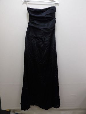 a black dress hanging on a hanger in a room