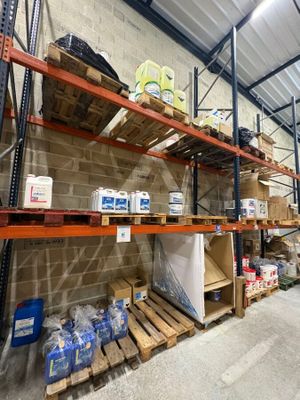 un grand entrepôt rempli d'étagères et de palettes