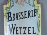 a sign that says brasserie wetzel with a cross on it