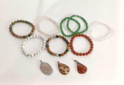 Plusieurs bracelets de différentes couleurs et formes sont disposés sur une surface blanche.