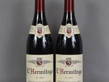 deux bouteilles de vin rouge posées sur une table en verre