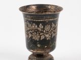 a black vase with a gold design on it