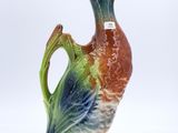 a ceramic duck that is sitting on the ground