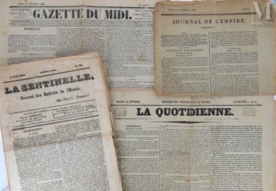 Plusieurs vieux journaux sont empilés les uns sur les autres sur une table
