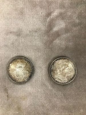 deux pièces d'argent posées sur un tissu blanc