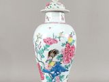 un vase blanc orné d'un oiseau et de fleurs
