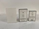 two empty boxes of perfume sitting next to each other on a white surface