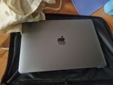 an apple laptop sitting on top of a black bag