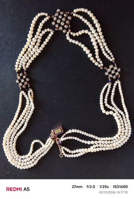 un gros plan d'un collier posé sur une table, sur fond noir