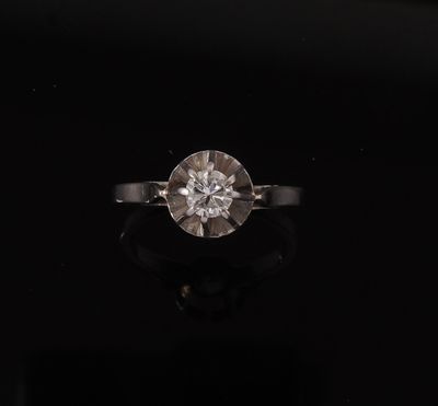 une vieille bague sertie d'un diamant taillé, posée sur une surface noire
