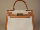 une photo d'un sac à main blanc et beige muni d'une poignée marron