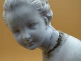 a white statue of a child with a collar around his neck