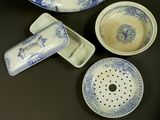 several pieces of blue and white pottery are on a table