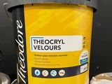 a bucket of yellow paint sitting on top of a table