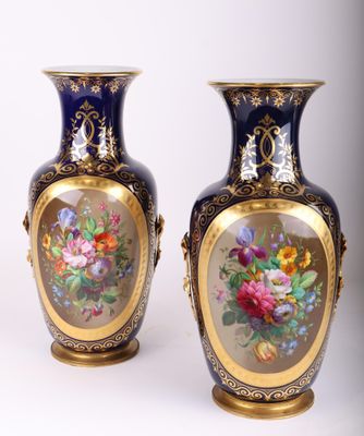 une paire de vases bleus ornés de fleurs peintes, posés sur une table