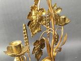 a gold candle holder with two candles on it
