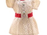 robe beige et rouge sur un mannequin, ornée d'un ruban rouge