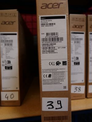 boxes of acer products are stacked on a shelf in a store