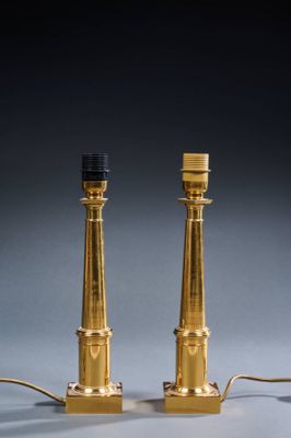 a pair of brass table lamps with black lampshads