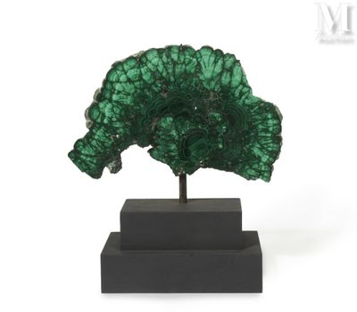 a close up of a green piece of rock on a black stand