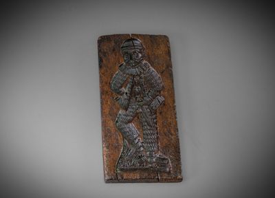 une plaque en bois sur laquelle figure un homme tenant une épée