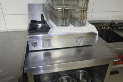 une grande friteuse posée sur un plan de travail dans une cuisine