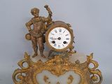 a gold clock with a statue on top of it