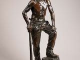 statue of a man standing on a stump with a stick