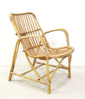 a wicker chair that is sitting on a concrete floor
