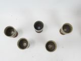 several cups are arranged in a circle on a white surface