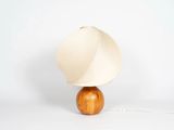une lampe dotée d'un pied en bois et d'un abat-jour blanc