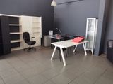 une photo d'une pièce avec un bureau, une chaise et une bibliothèque